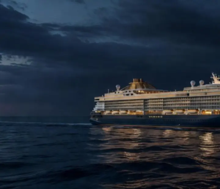 A luxury ocean liner gliding through twilight seas with golden reflections.